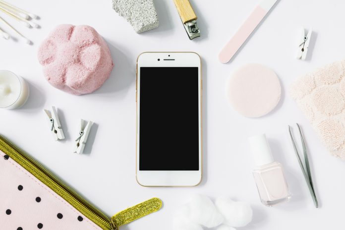 elevated-view-smartphone-surrounded-with-various-spa-products-white-surface