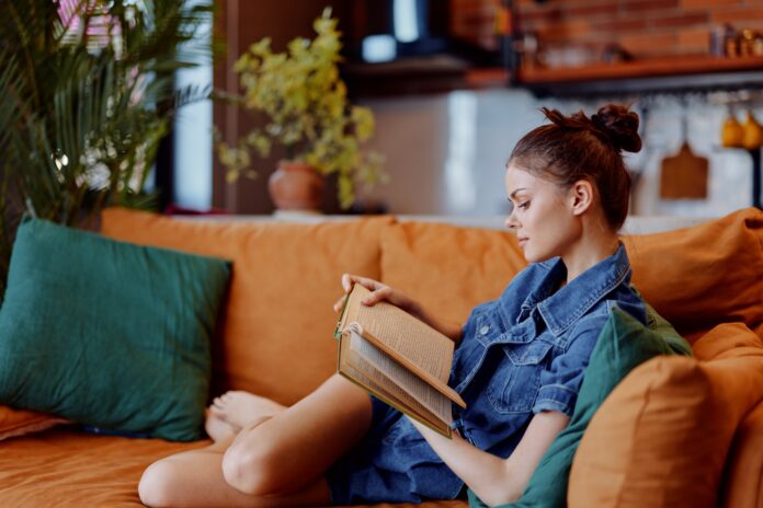 Young,Woman,Enjoying,A,Relaxing,Moment,Reading,A,Book,On