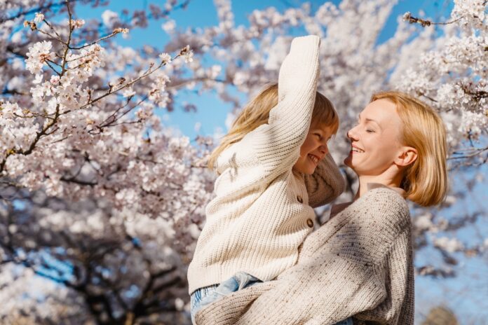 Mother,And,Daughter,Are,Happy,Together,In,Blooming,Trees,Garden
